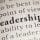 Close-up of a dictionary page showing the word "Leadership" in bold, with surrounding text slightly blurred.